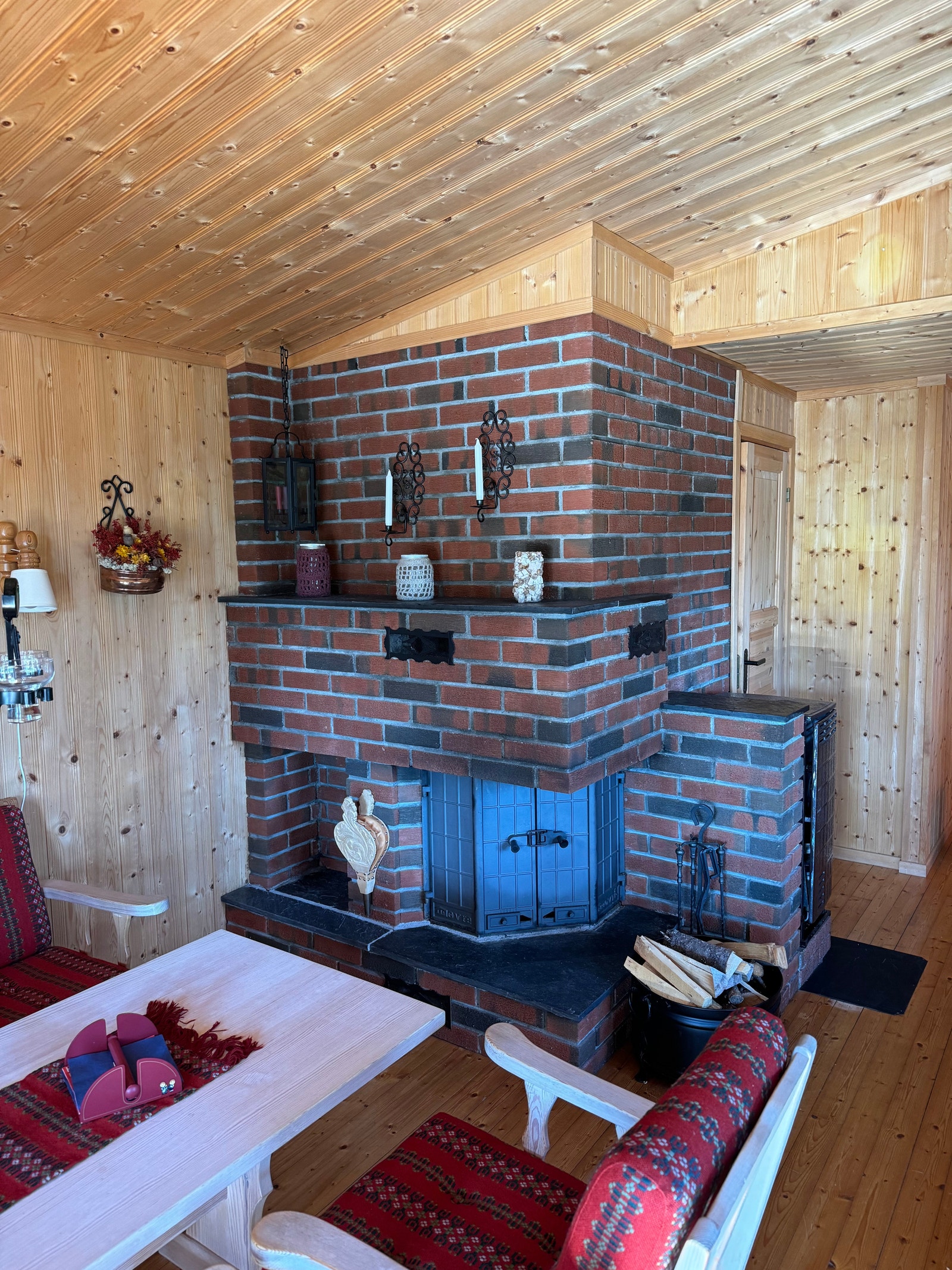 Peisinnsats i en flott teglstein-omramming. Kombinert ved og parafinovn på siden. Galleribilde