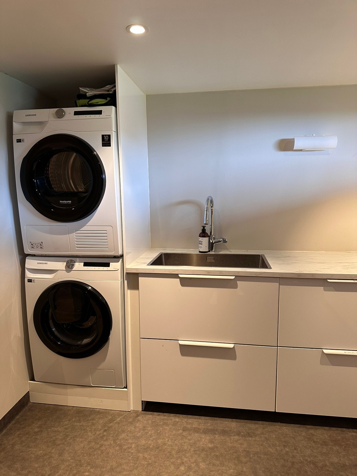 Vaskerom med vaskemaskin og tørketrommel i kjeller Galleribilde