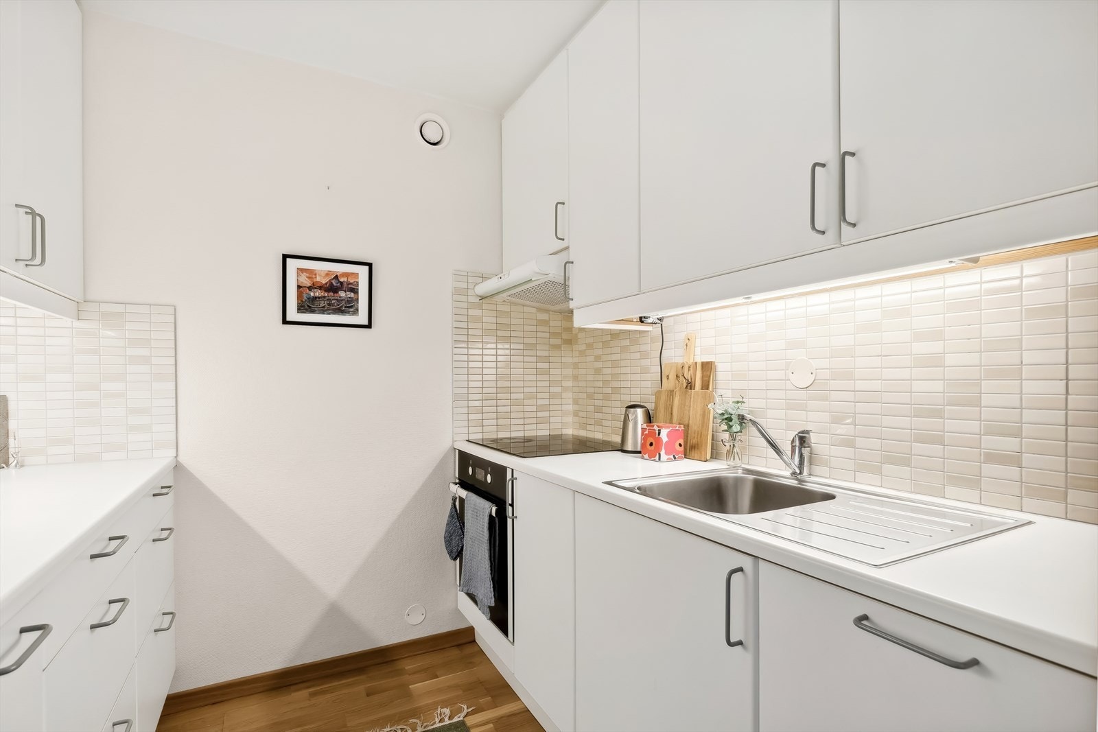 Videre er kjøkkenet utstyrt med kjøl/fryseskap, platetopp, stekeovn og kjøkkenventilator med kullfilter. Galleribilde