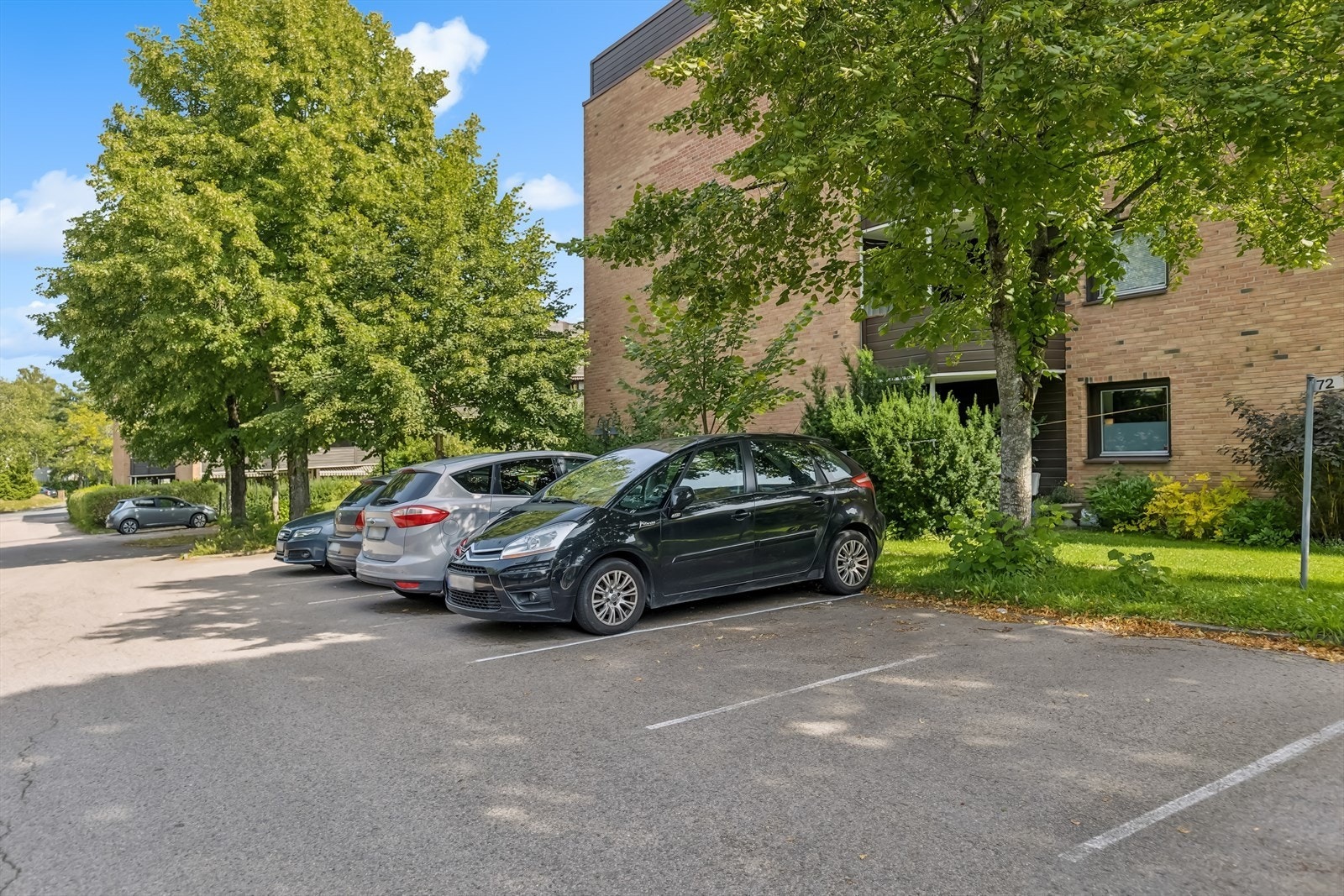 Boenheten har tilhørende biloppstillingsplass nummer 37 for en bil på en felles parkeringsplass. Galleribilde