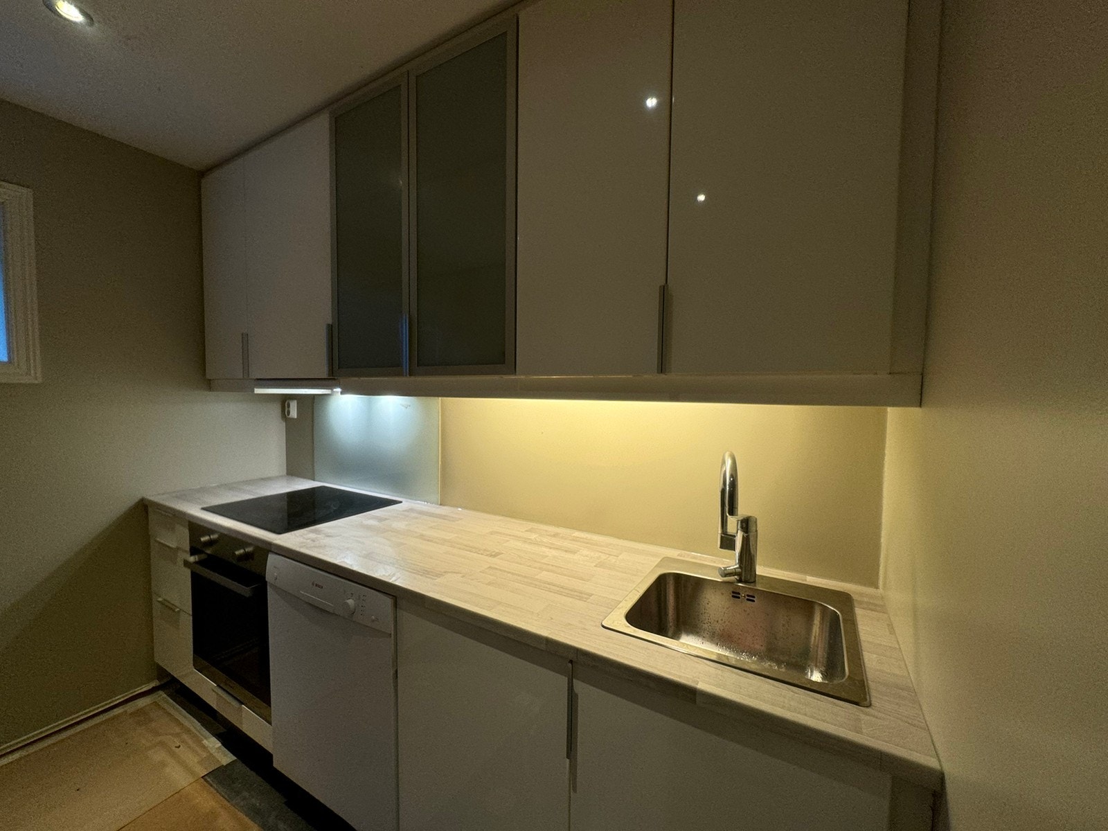 Høyglanset hvit IKEA kjøkken med hvitevarer. Veggene er nymalt med den delikate fargen Soothing Beige Galleribilde