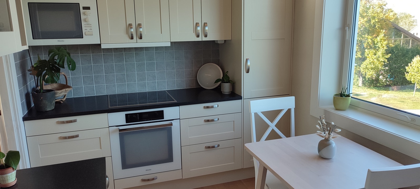 Moderne kjøkken med spiseplass og integrerte hvitevarer. Galleribilde