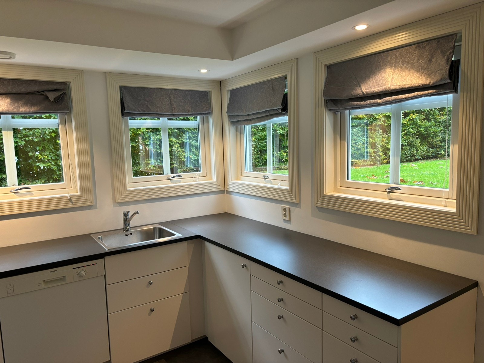 Lyst og pent kjøkken med hvitevarer inkludert Galleribilde