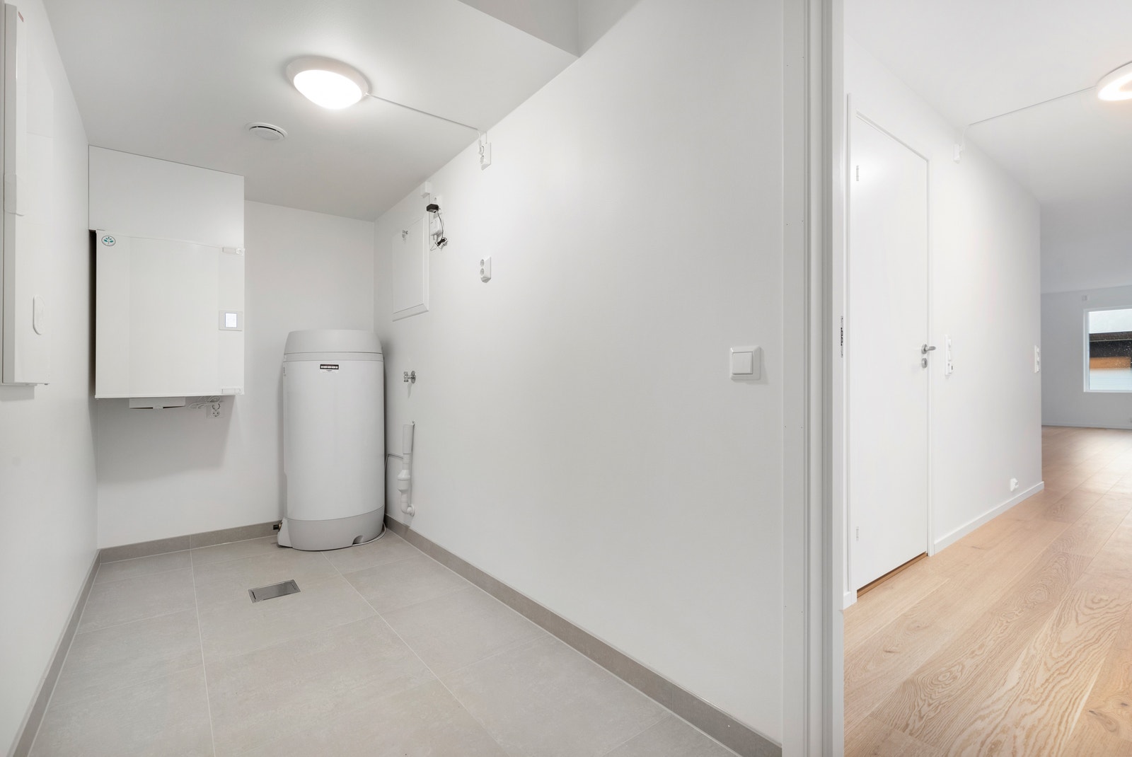 Romsleg bod/vaskerom med opplegg for vaskemaskin og tørketrommel. Bilde frå ledig seksjon. Galleribilde