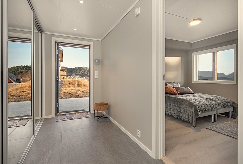 Entrè med stor skyvedørsgarderobe og flislagt golv med varmekablar Galleribilde