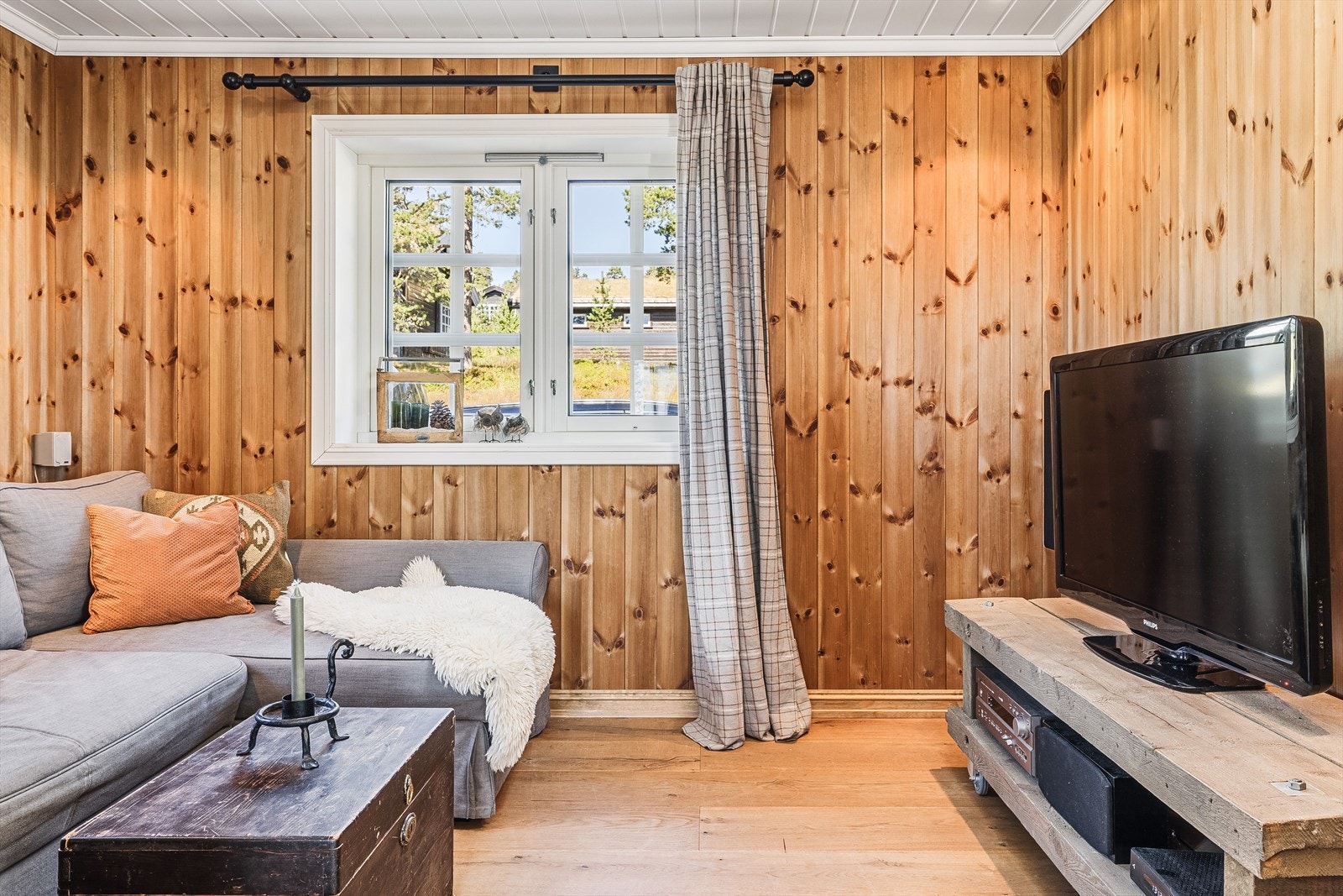 Innenfor kjøkkenet er det en smart og trivelig tv-stue med adkomst via en stilfull skyvedør. Galleribilde