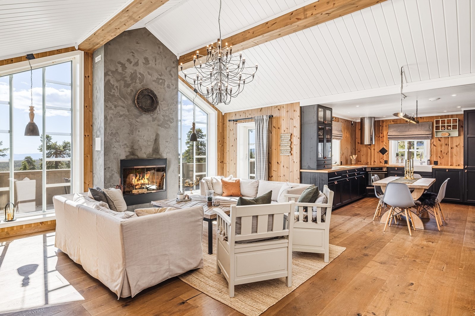 Hytta har et herlig stue- og kjøkkenrom med en helt egen wow-faktor. De store vinduene med nydelig utsikt, god takhøyde og den stilige peisen bidrar til en flott lodge-følelse. Galleribilde