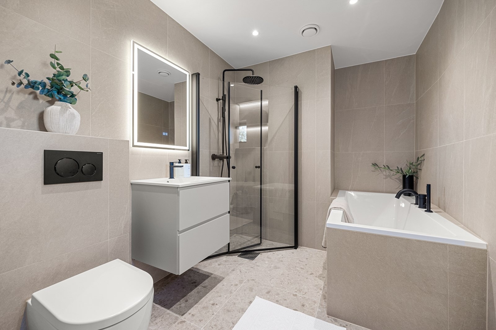 Hovedbadet, som tilhører hovedsoverommet, er flislagt med sandtonede fliser og varmekabler. Galleribilde