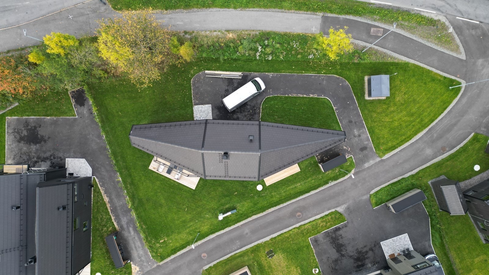 Pent opparbeidet tomt med gressplen og asfaltert adkomst i en tunløsning. Galleribilde