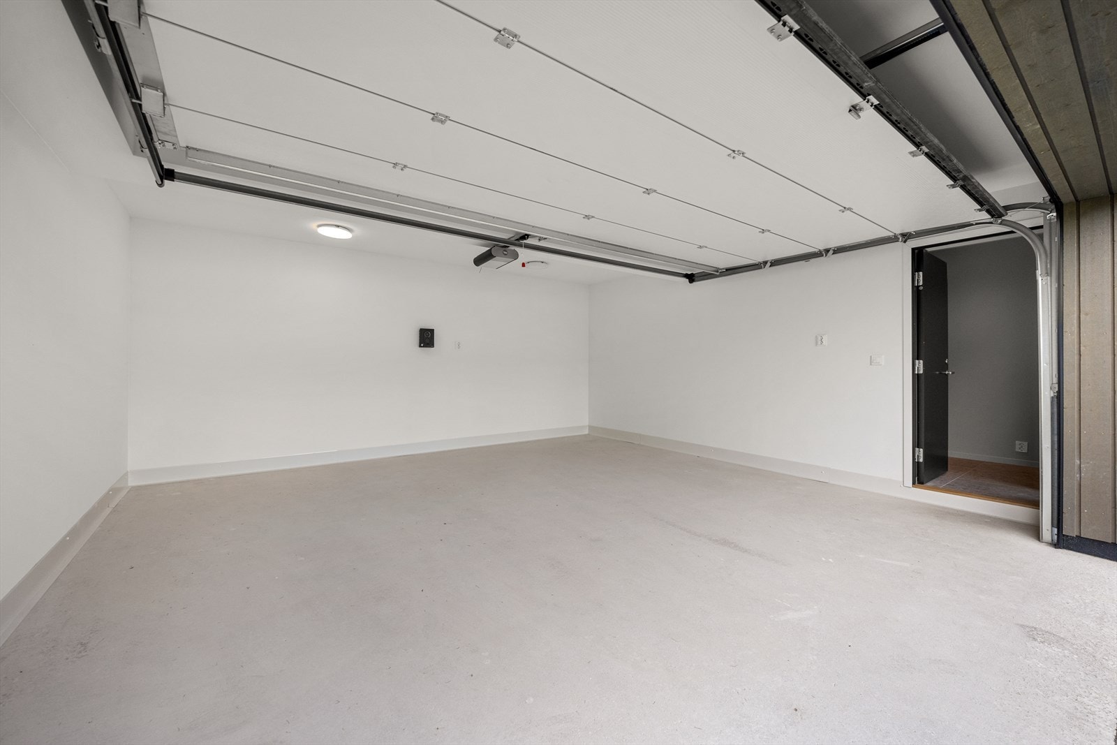 Garasjen er integrert og utstyrt med ladestasjon for elbil og her er det direkte adkomst til boligens entré. Galleribilde
