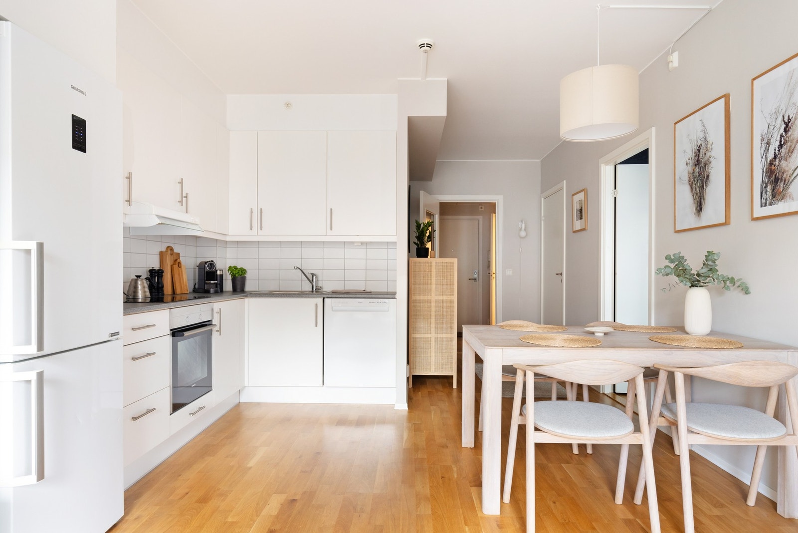 Lyst kjøkkenhjørne med glatte fronter, laminat benkeplate og nedfelt oppvaskkum med ett-greps blandebatteri. Galleribilde