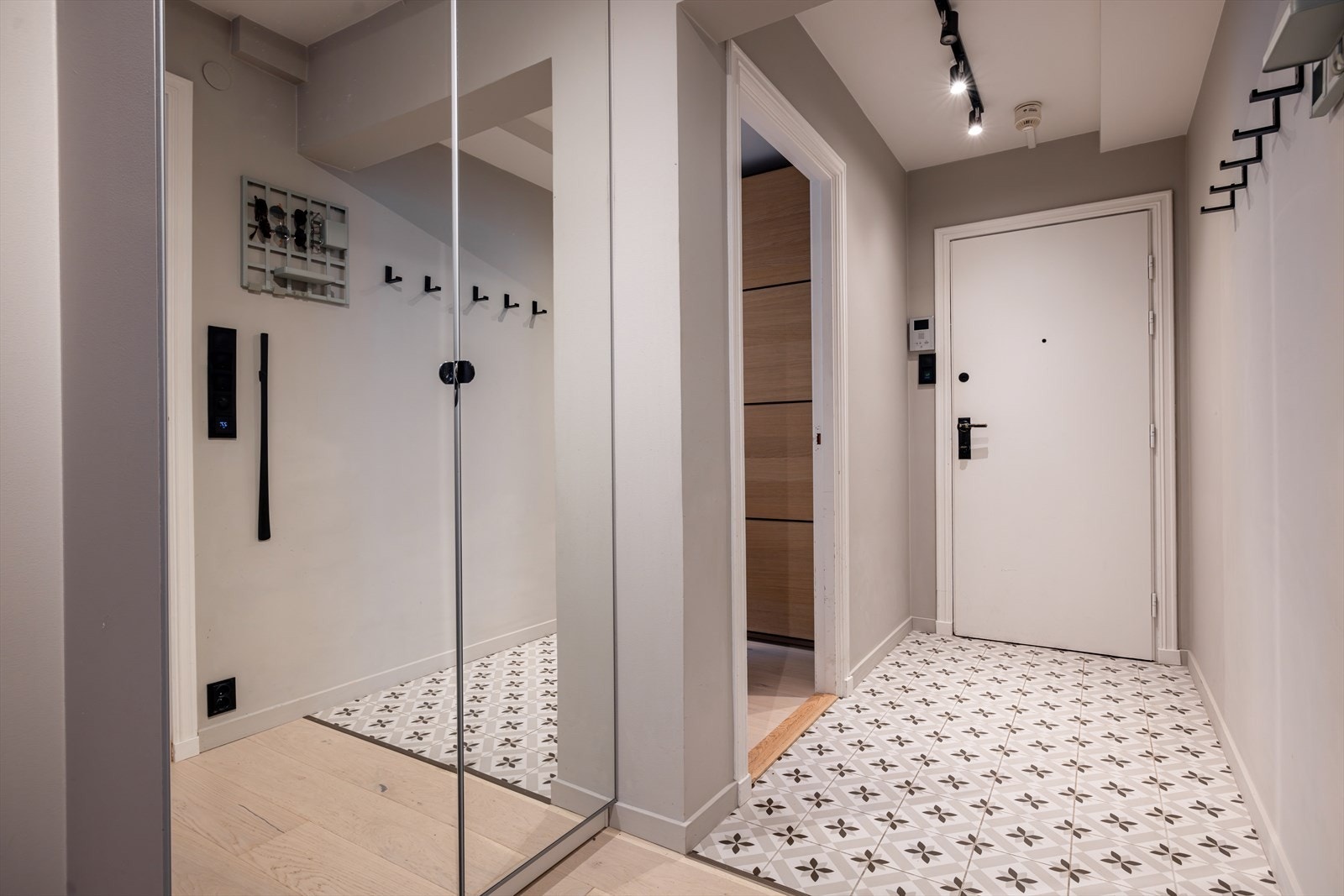 Entré med porttelefon med kamera. Fliser på gulv med varme. Plass til skoskap, knagger eller lignende. Skap til høyre med glassfronter for yttertøy. Galleribilde