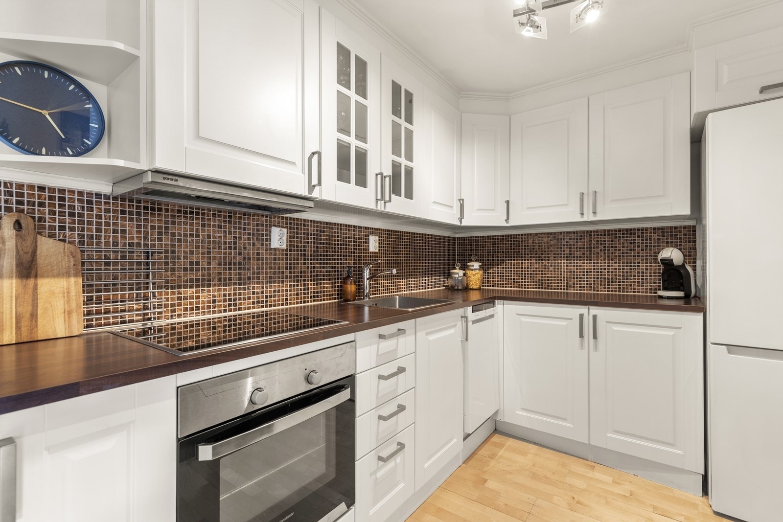 Delvis separat kjøkken med innredning av profilerte fronter og benkeplaten er av laminat. Galleribilde