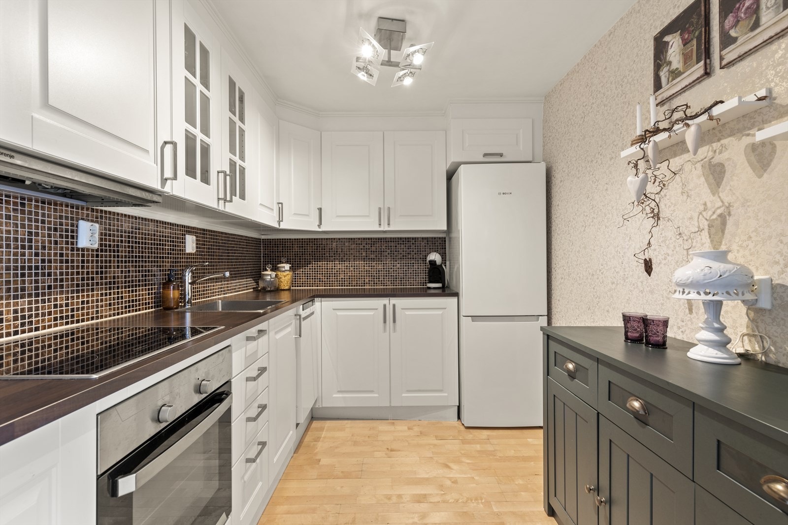 Det er integrerte hvitevarer som komfyr og platetopp, samt opplegg for kjøleskap og oppvaskmaskin. Galleribilde