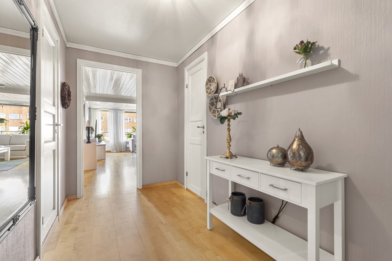 Vel inne er det en pen entré med lysmalte vegger og parkettgulv. Yttertøy, sko og utstyr kan ryddes bort i den innvendige boden. Galleribilde