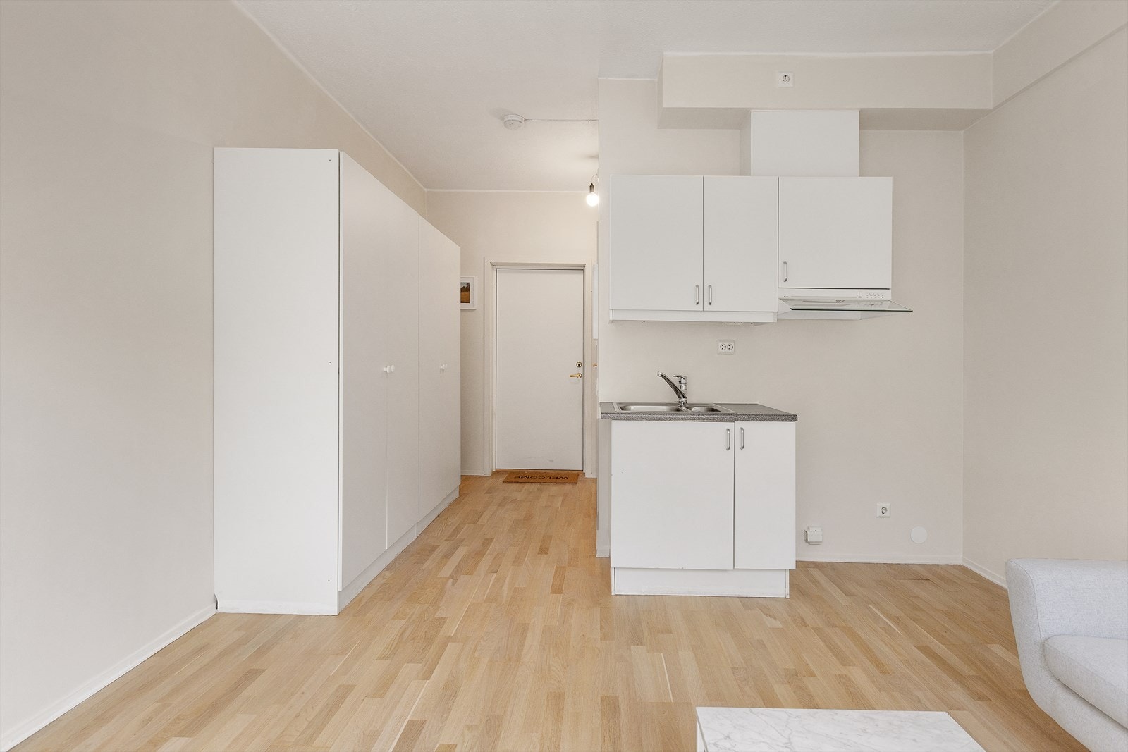 Kjøkkeninnredning med glatte fronter, laminert benkeplate, oppvaskkum og ventilator. Galleribilde