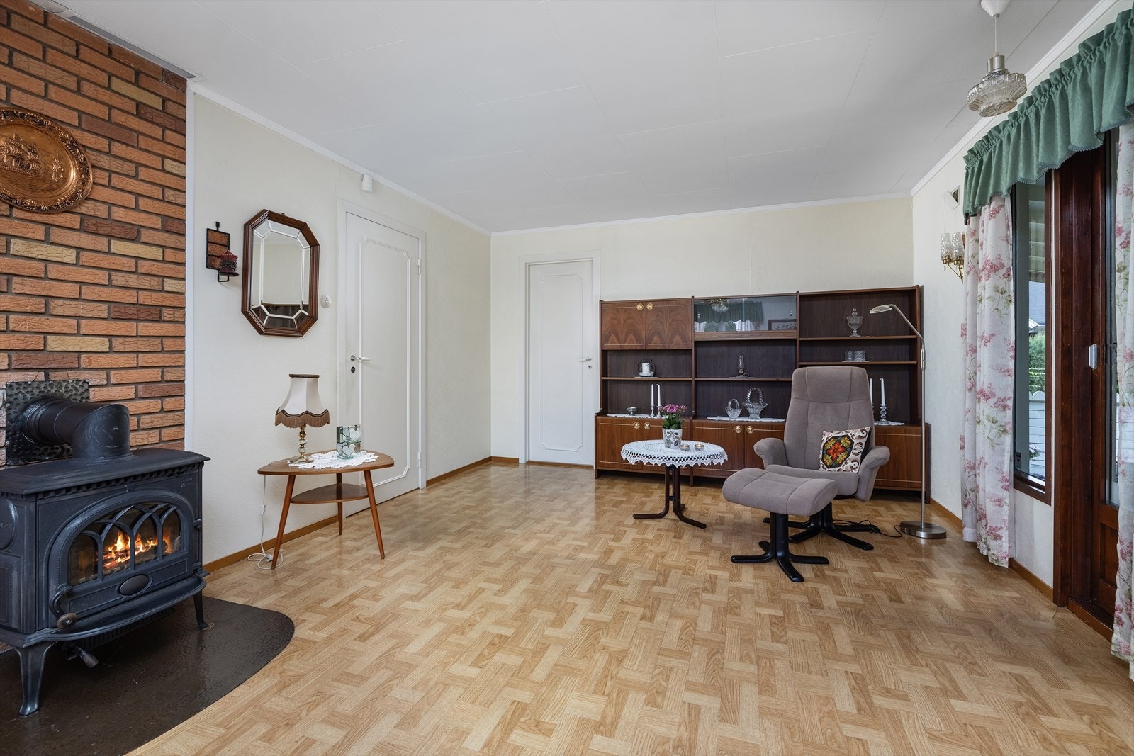 Stuen er lys og innbydende med belegg på gulv og veggene har malt tapet. Galleribilde