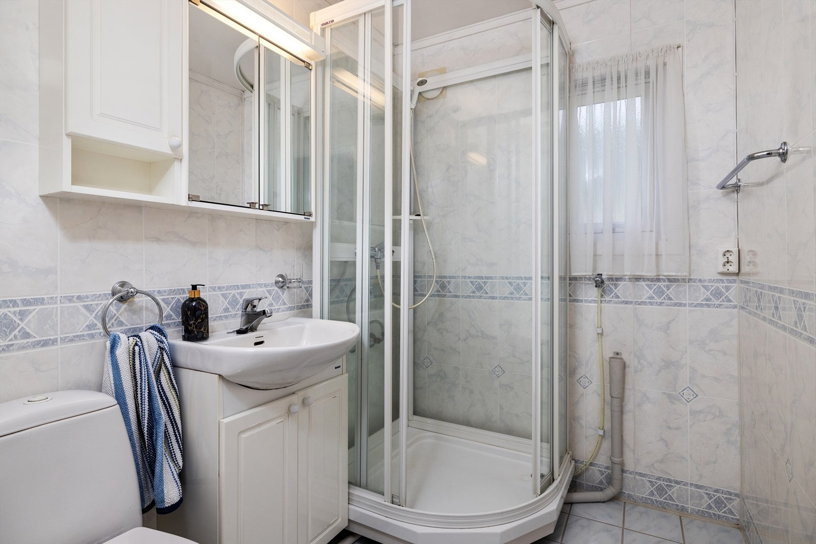 Eldre men velholdt, flislagt bad med sanitærutstyr bestående av klosett, servant med innredning og dusjkabinett. Badet må oppgraderes for å tåle normal bruk etter dagens krav. Galleribilde