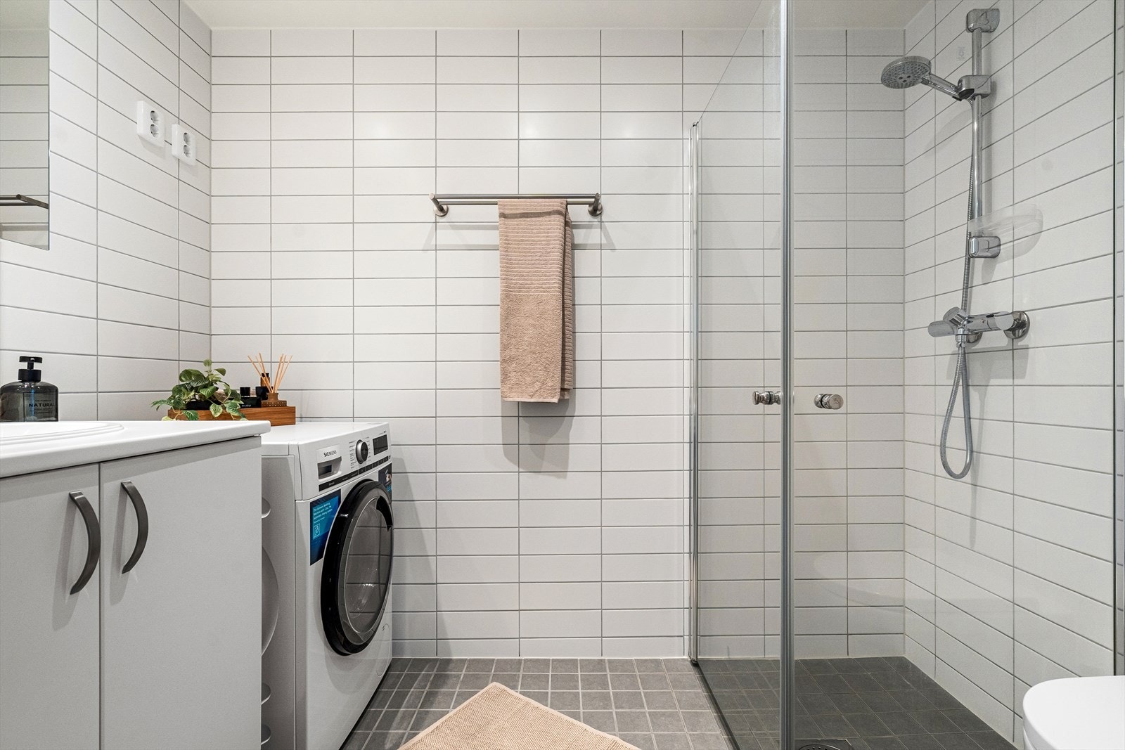 Lekkert bad fra 2017 med flislagte overflater, gulvvarme og downlights i himling. Det er opplegg for vaskemaskin. Galleribilde