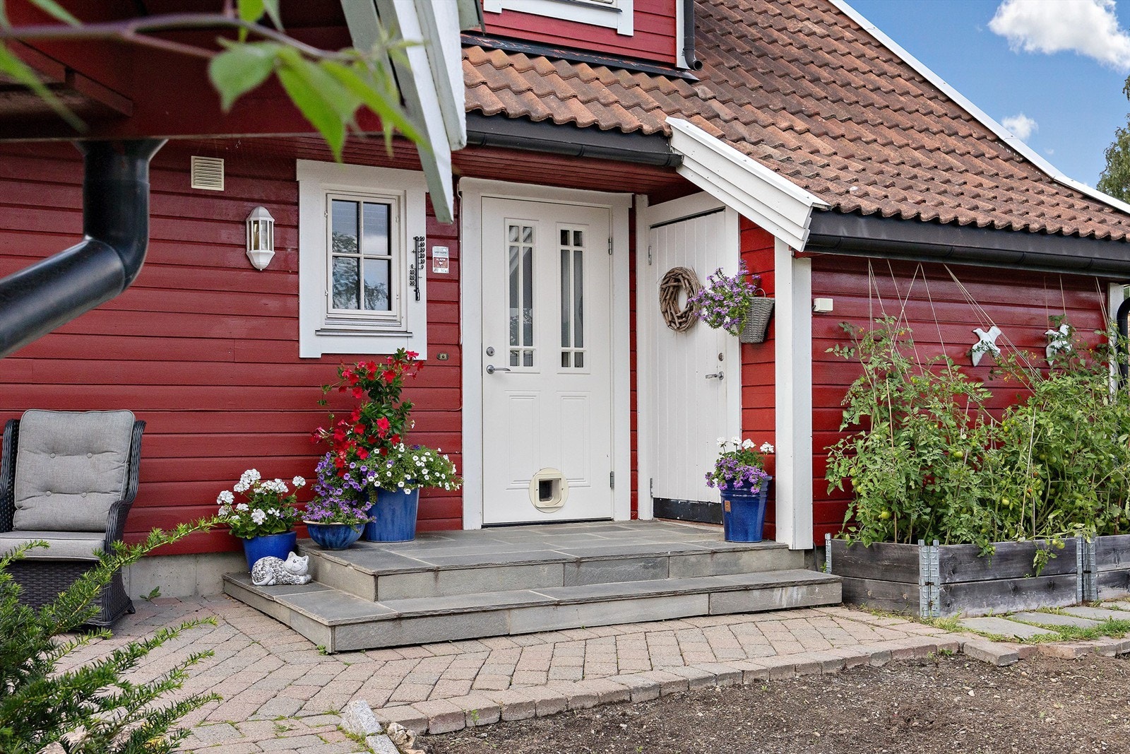 Hyggelig, delvis overbygget inngangsparti med belegningsstein og skifertrapp Galleribilde