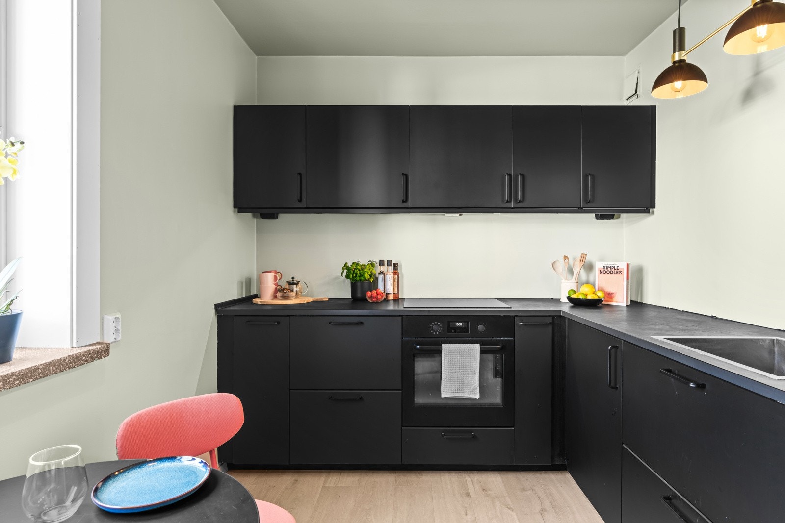 Ikea-innredningen fra 2020 har sorte, glatte fronter og mørk benkeplate av laminat. Alle hvitevarer er integrert, bestående av platetopp, stekeovn, oppvaskmaskin og en kombinert kjøl/frys Galleribilde