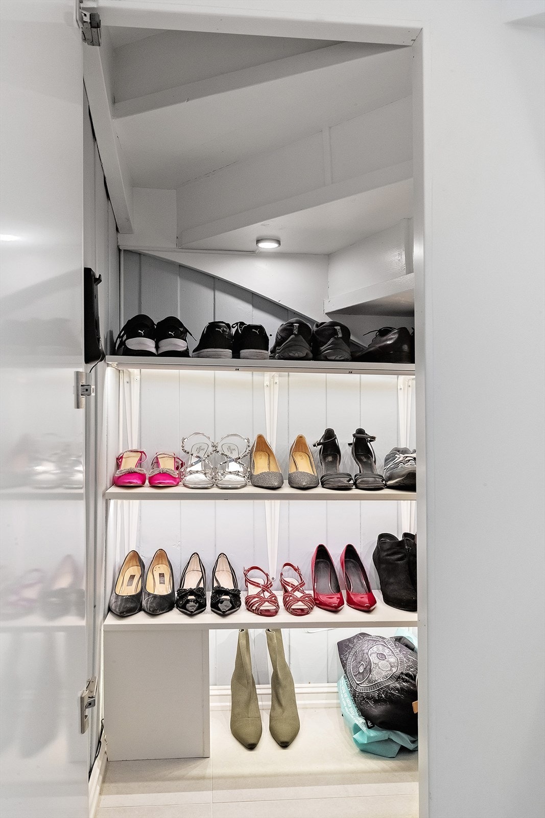 Under trappen opp til 1. etasje er det et praktisk, lite rom med hylleløsninger for sko og diverse Galleribilde