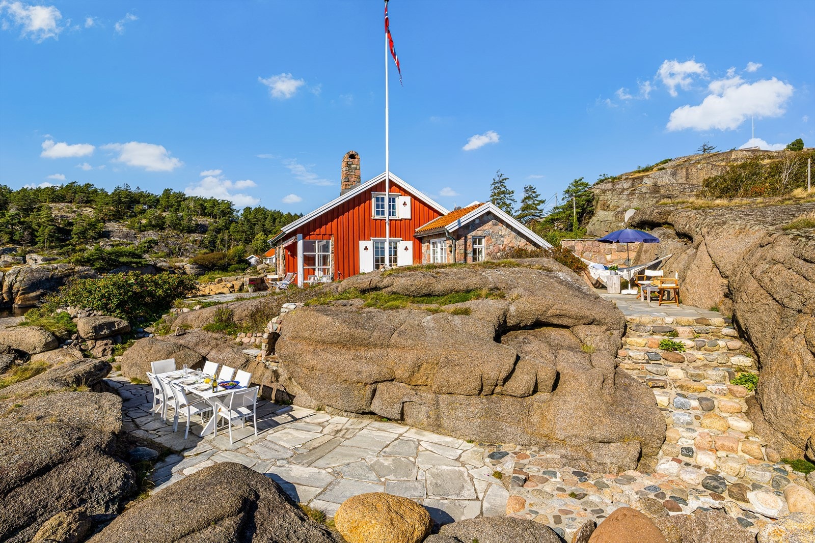 Terrassene er anlagt mellom svabergene, og den nederste har murt utepeis for ekstra hygge. Galleribilde