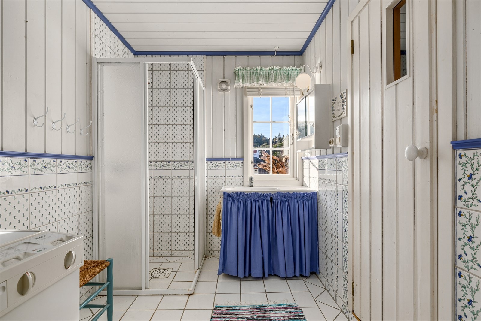 Badet er dels flislagt og har dusjhjørne, opplegg for vaskemaskin og inngang til badstue. Galleribilde