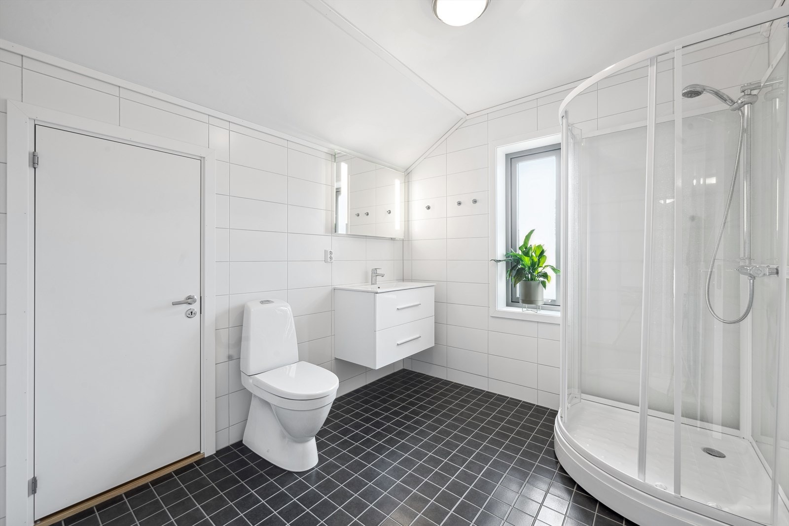 Pent flislagt bad i loftsetasjen med dusjkabinett, wc og innredning m/vask. I tillegg er det kott for oppbevaring. Galleribilde