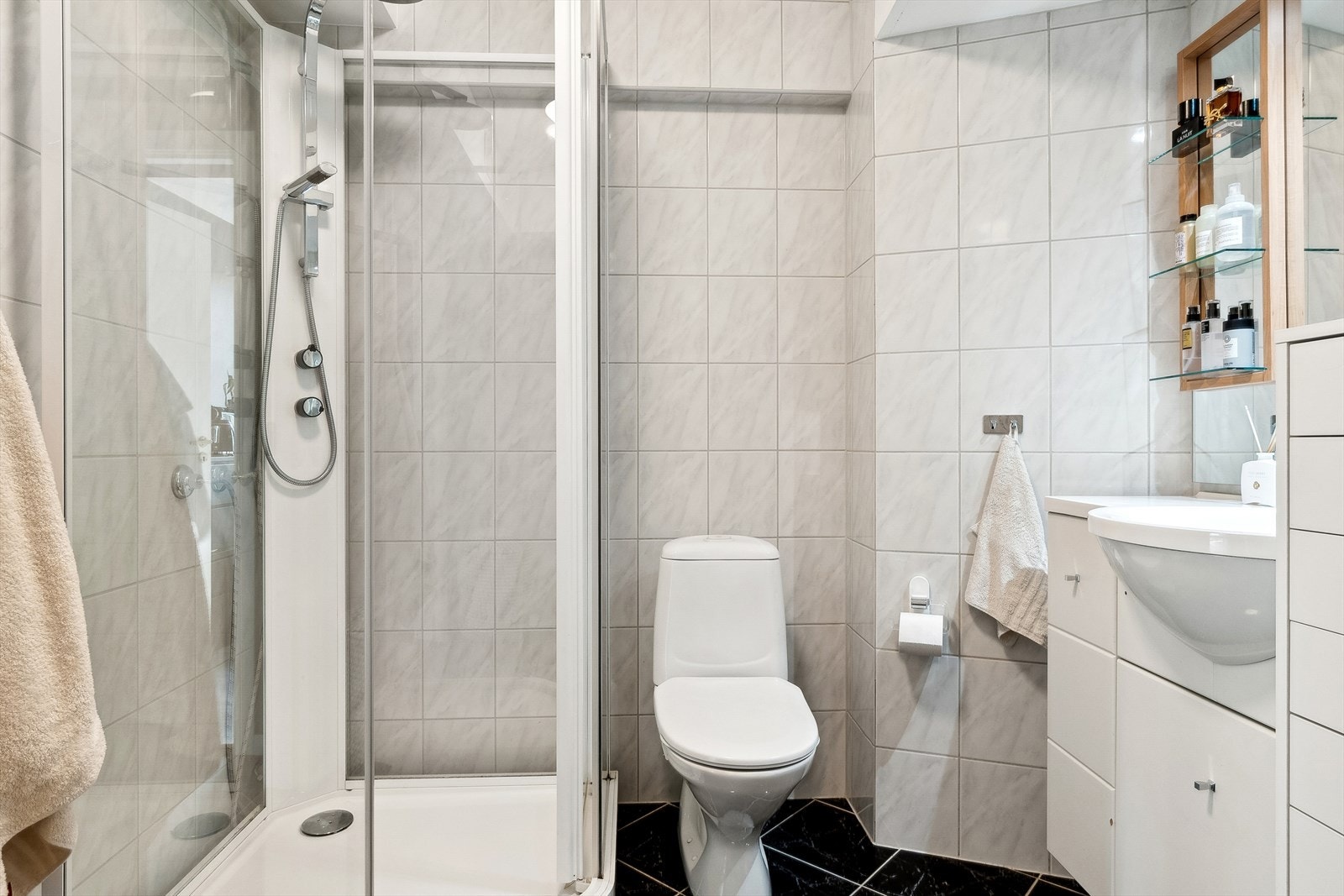 Badet er innredet med servant med oppbevaringsplass, WC og dusjkabinett. Det er også opplegg til vaskemaskin Galleribilde
