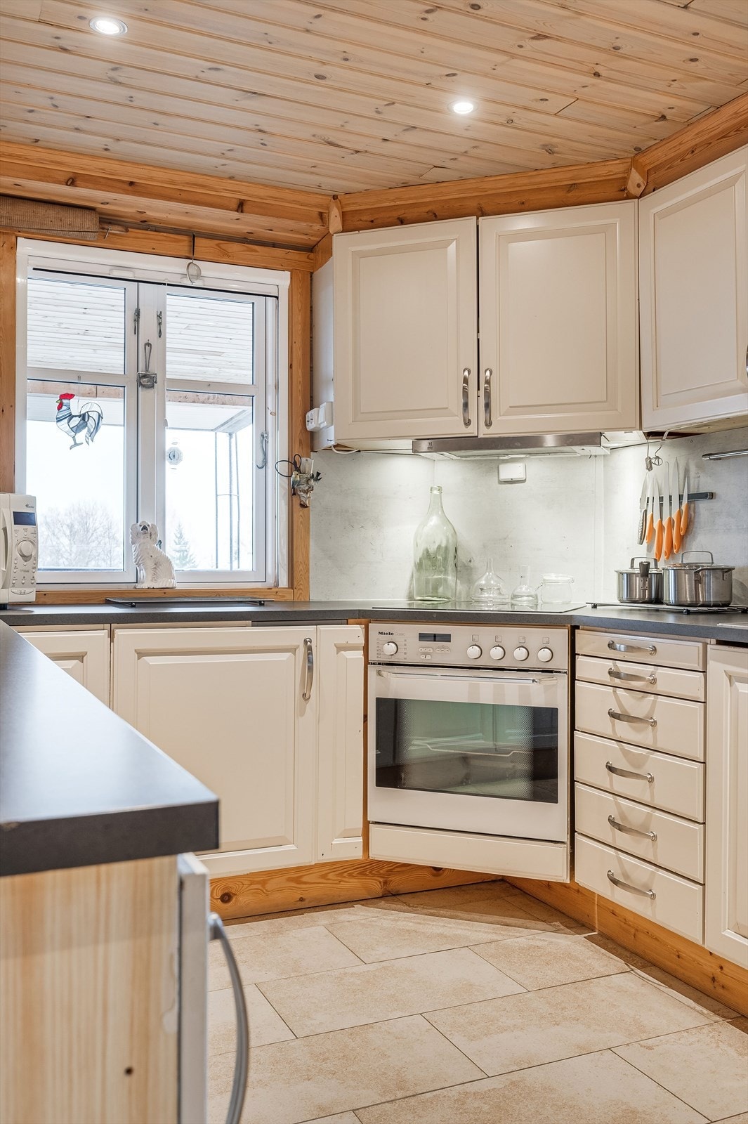 Lys og tidløs kjøkkeninnredning med god skap- og benkeplass. Innredningen har lyse profilerte fronter og laminert benkeplate med nedfelt oppvaskkum. Galleribilde