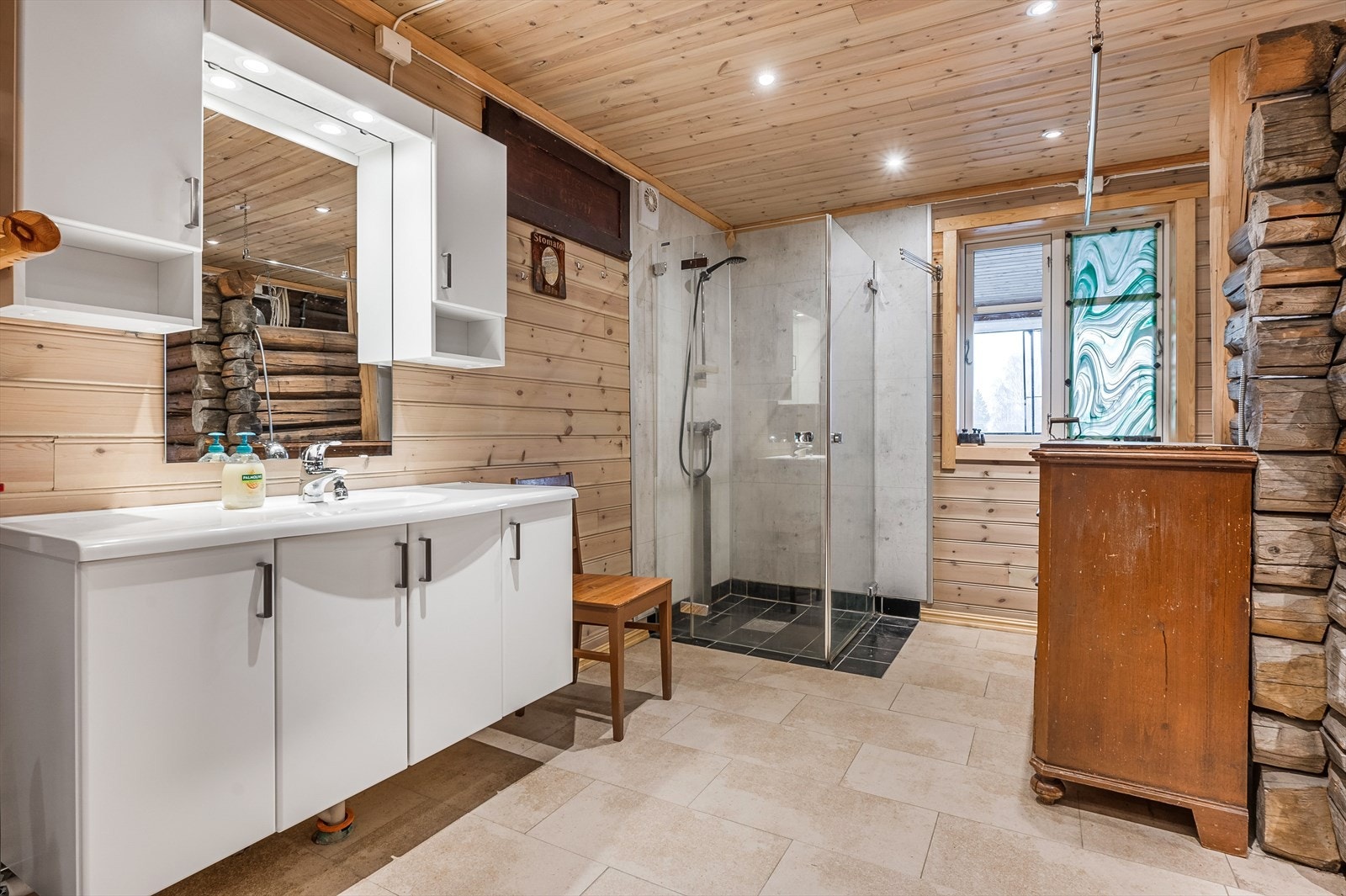 Baderommet er også utstyrt med dusjhjørne med innfellbare glassdører og opplegg for vaskemaskin. Galleribilde