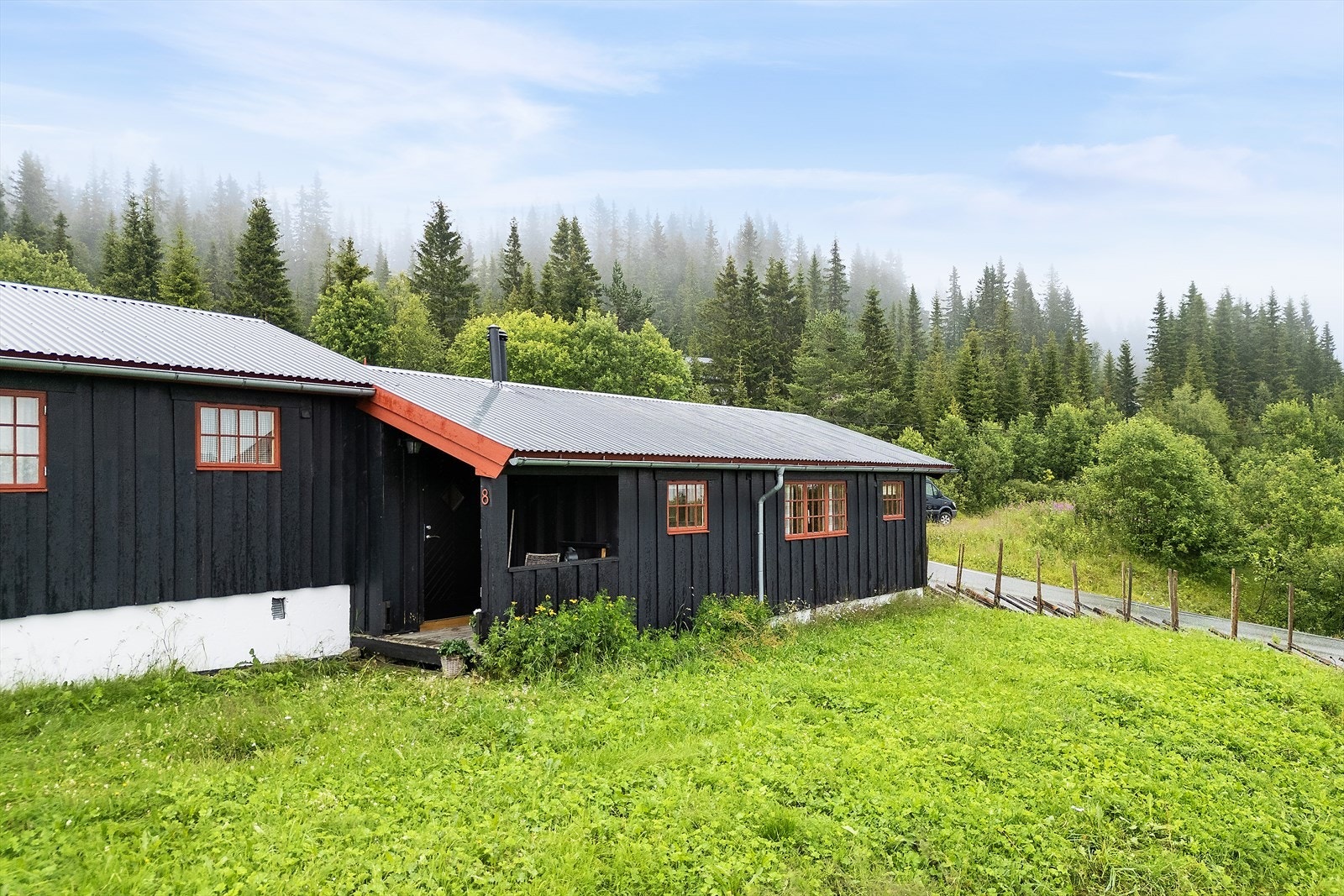 Felles tomt med plen rundt bygningene. Galleribilde