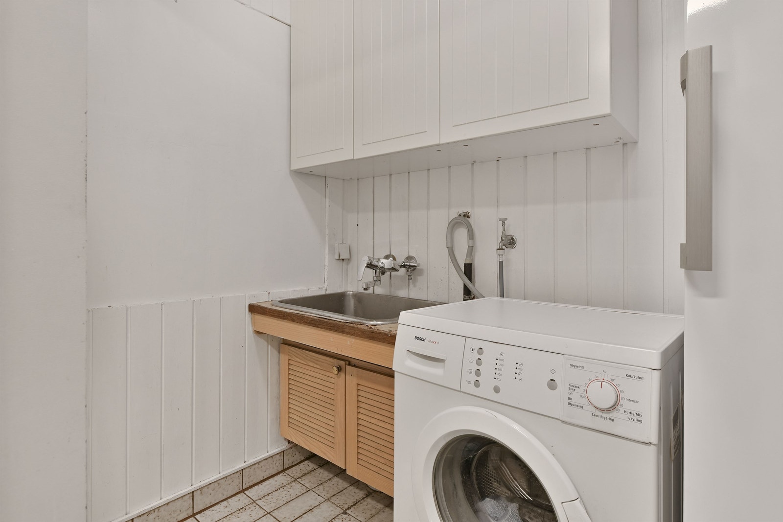 Vaskerom - flislagt gulv - skapplass - utslagsvask - opplegg til vaskemaskin Galleribilde