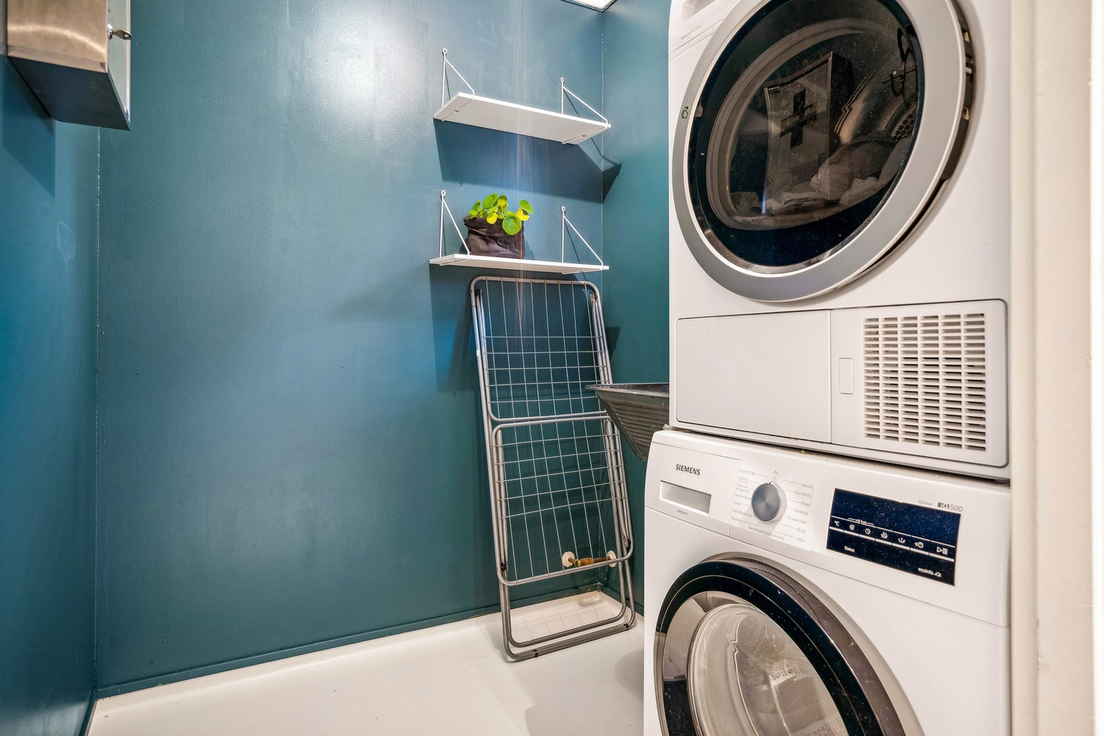 Vaskerom fra byggeår med opplegg for vaskemaskin og utslagsvask i stål. Det er ventil i himling til sentral avtrekk på loft. Tilluft via ventil i vindu. Galleribilde