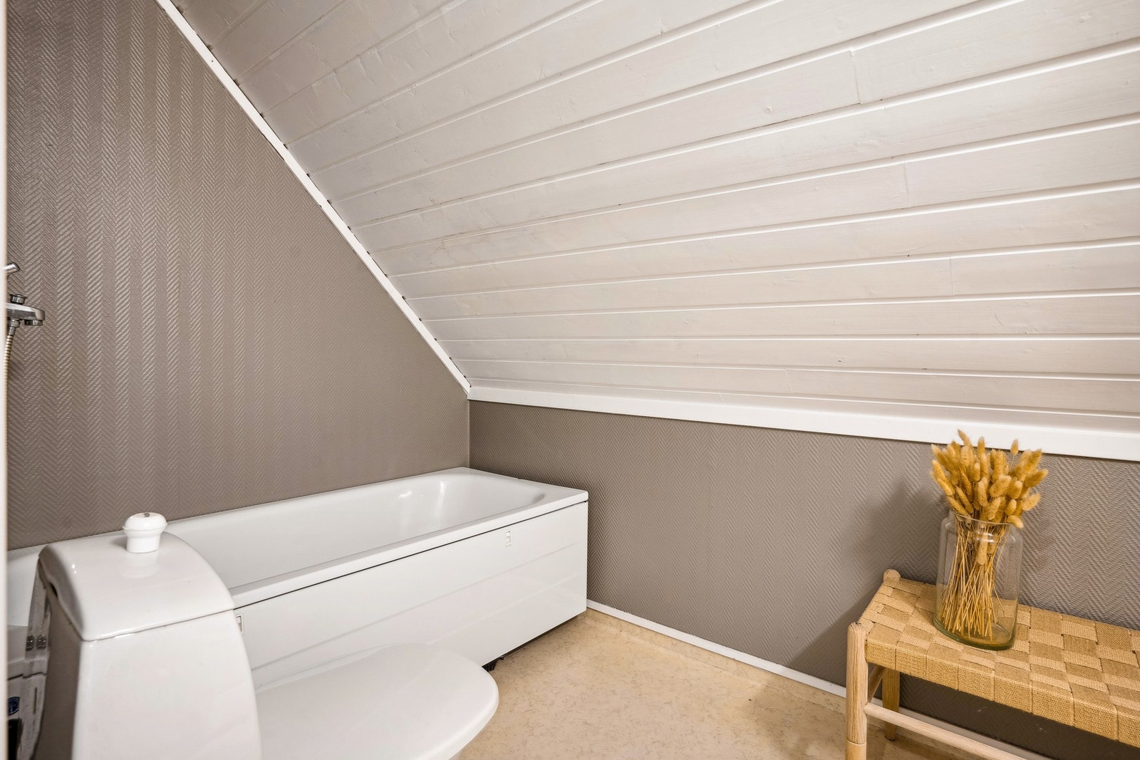 Et enkelt lite bad på loftet med badekar, toalett og vask. Galleribilde