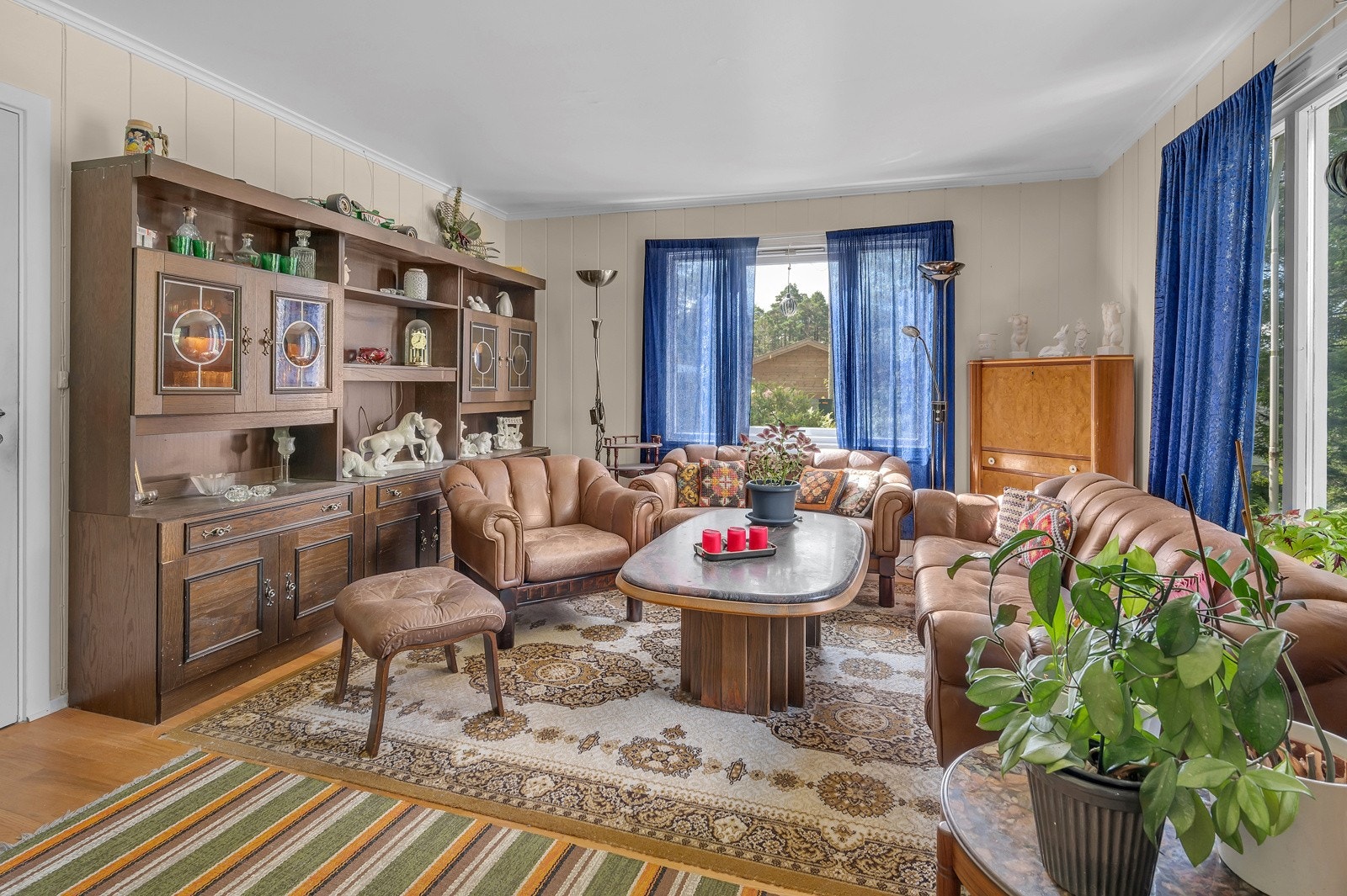 Stue med store vindusflater og flott utsyn mot grøntareal Galleribilde