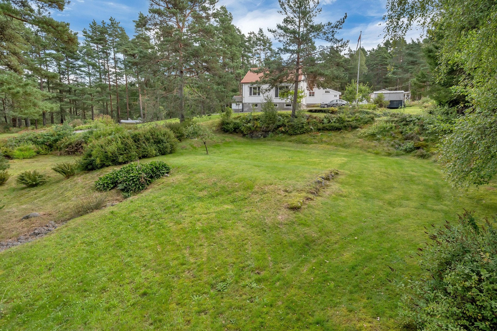 Innholdsrik eiendom med enebolig, anneks, garasje og store grøntområder Galleribilde
