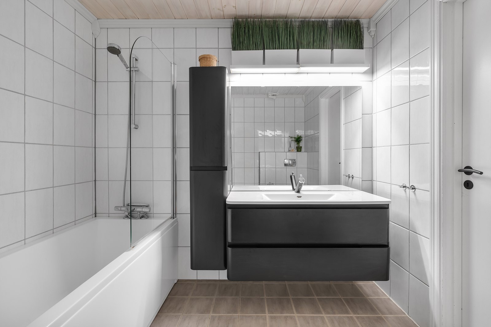 Badet har badekar og servant med baderomsinnredning Galleribilde