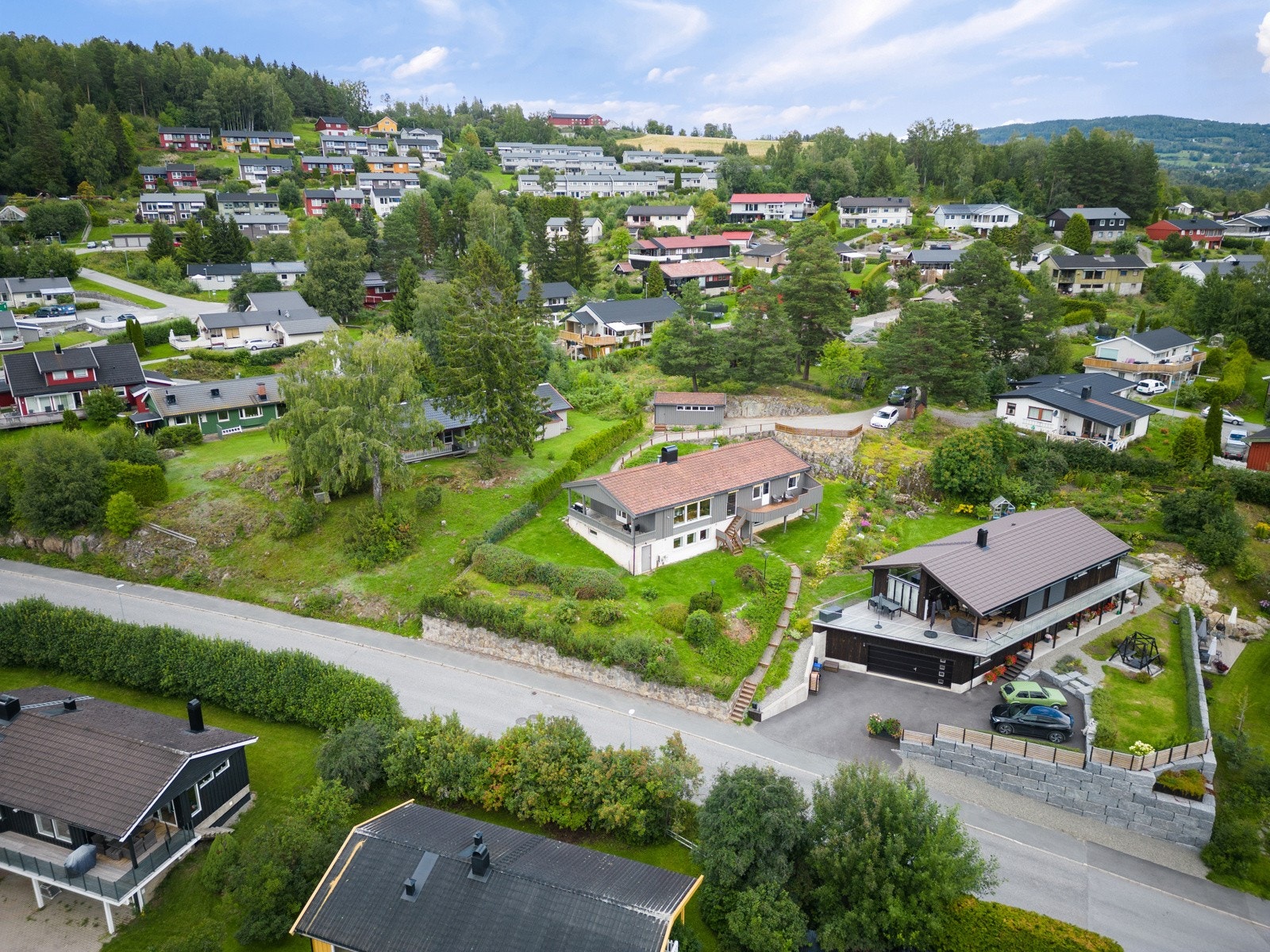Om sommeren er det en trivelig hage som er opparbeidet med plen og beplantning. Det er også etablert en sti ned fra fremsiden av huset. Galleribilde