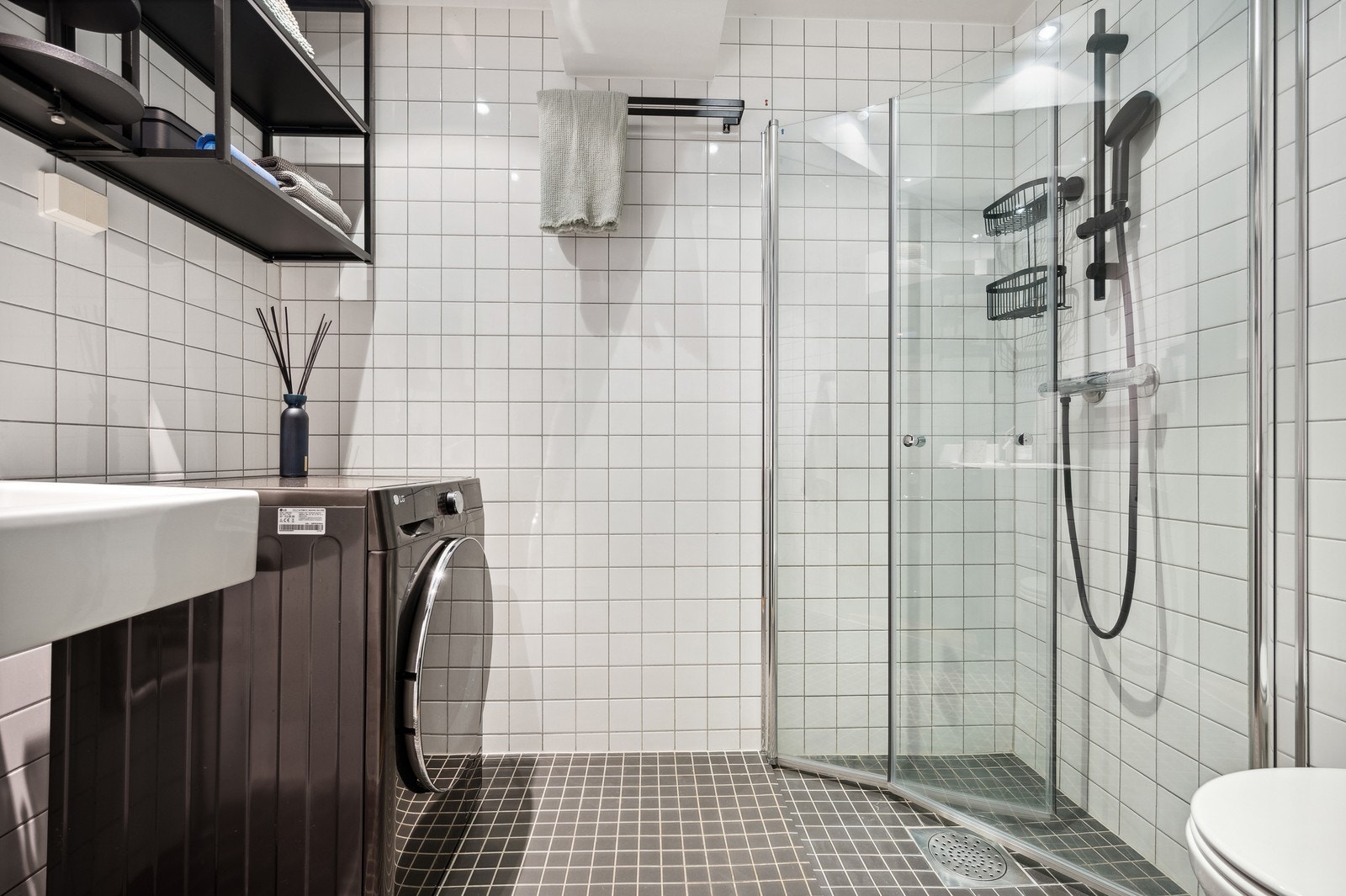 Flislagt bad med varmekabler og kombinert vaskemaskin/tørketrommel. Galleribilde