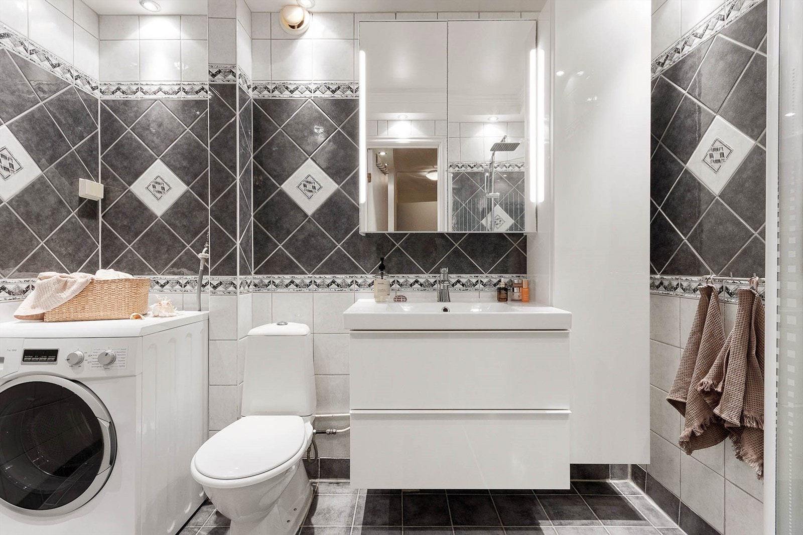 Romslig flislagt bad med opplegg for vaskemaskin Galleribilde