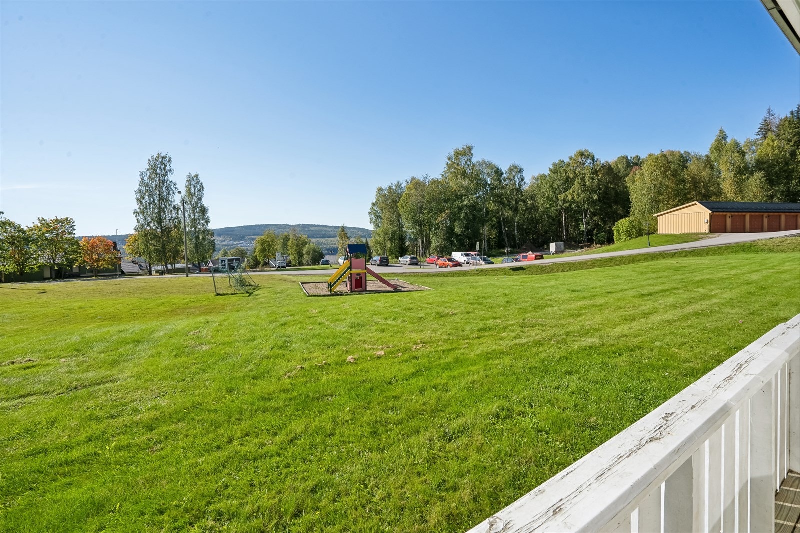 Fine og velstelte fellesarealer med plen, lekeplass, blomsterbed, som gir en innbydende inntrykk. Galleribilde