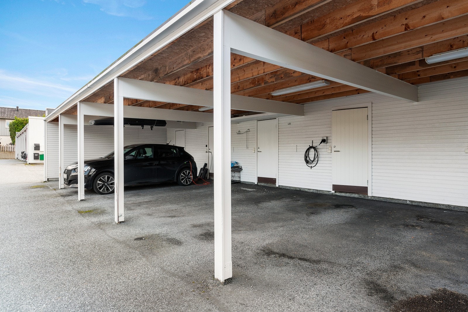 Bilen parkeres naturligvis i carporten. Her er det installert elbillader. Ellers godt med plasser for gjester. Galleribilde