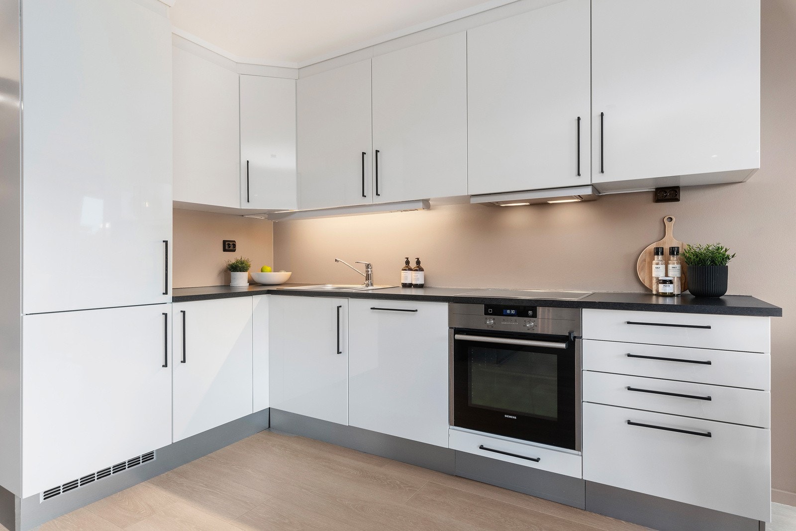 Kjøkkenet er utformet i en L-form og har integrerte hvitevarer. Galleribilde