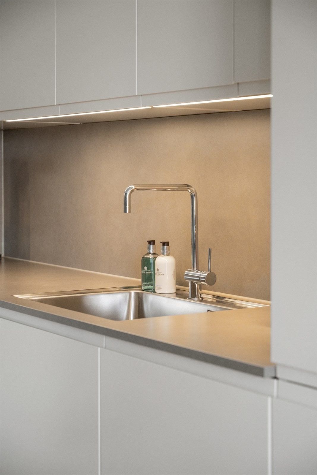 Kjøkkeninnredningen består av glatte, hvite fronter, laminat benkeplate og integrerte hvitevarer som komfyr/koketopp, kjøleskap/frys og oppvaskmaskin. Galleribilde