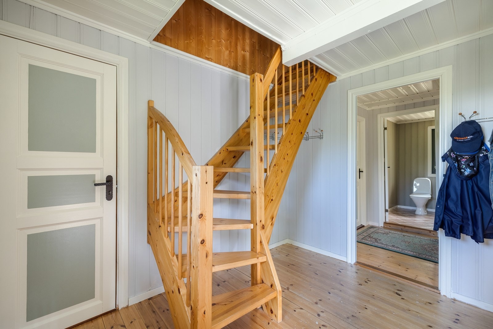 Hytta har en lys og romslig entré som ønsker velkommen inn! Her er det god plass til å sette fra seg sko og henge fra seg yttertøy. Her går det trapp opp til 2.etg. Galleribilde