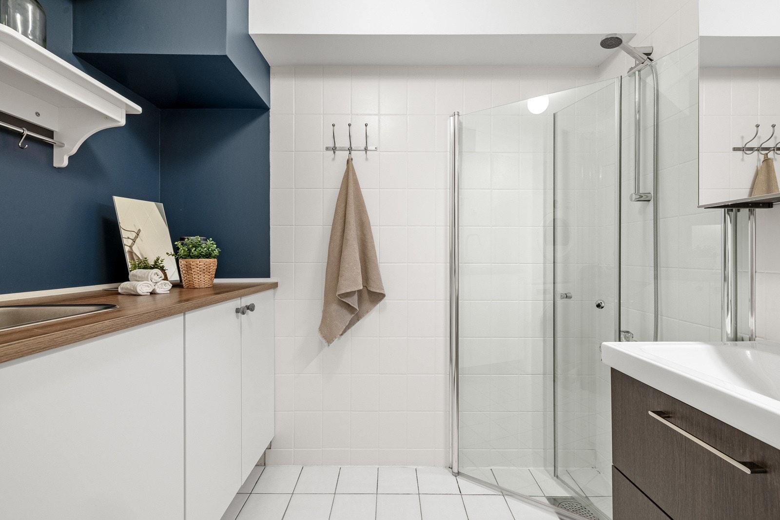 Badet er har fliser og delvis tapet på vegger. Taket har malte flater og gulvet er fliselagt. Det er selvfølgelig varme i gulv. Galleribilde