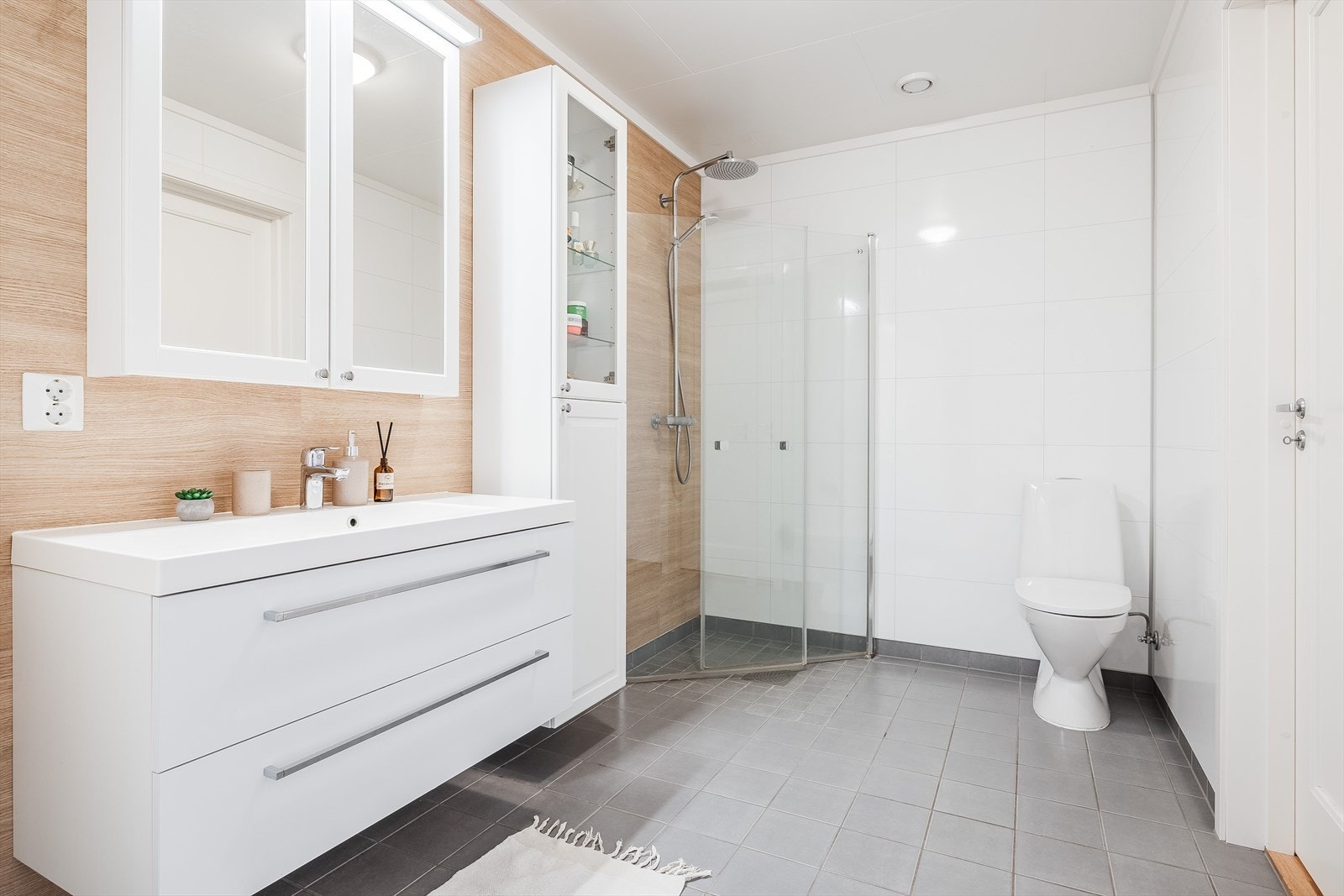 Lyst og delikat baderom fra byggeåret 2019. Baderommet har dusjhjørne med innfellbare glassdører og både hånd- og regnfallsdusj. Galleribilde