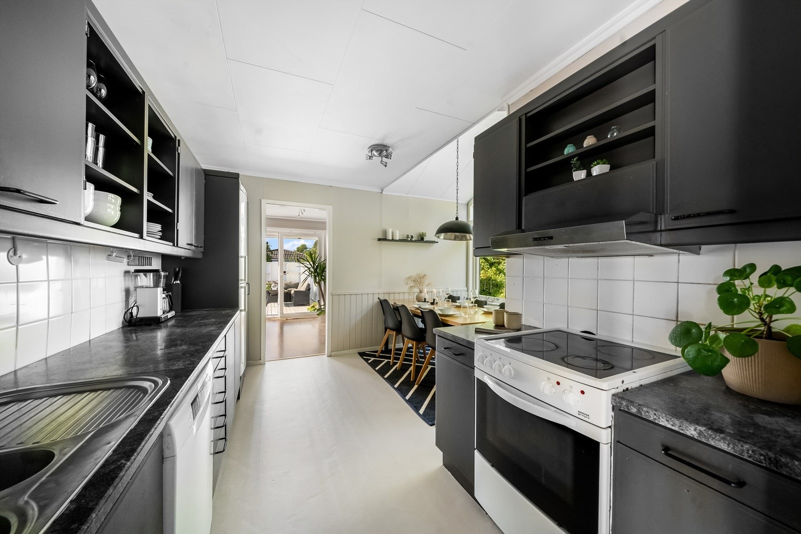 Kjøkkenet har innredning med profilerte fronter og benkeplate av laminat Galleribilde